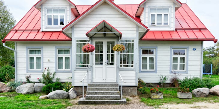 A photograph of a red and white house taken by a real estate photography business.