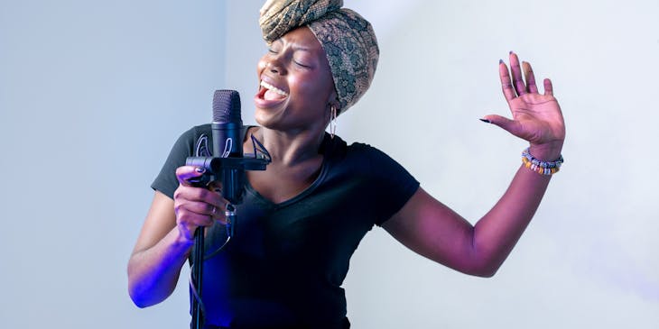 A woman recording song at rehearsal studio.