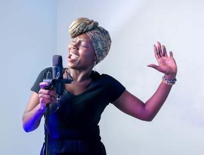 A woman recording song at rehearsal studio.