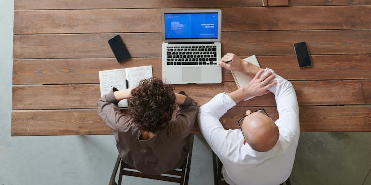 A view of three people having a meeting at a recruitment agency.