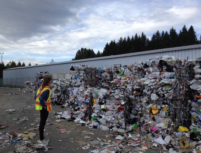 Pessoa inspecionando lixo reciclado em uma empresa de reciclagem.