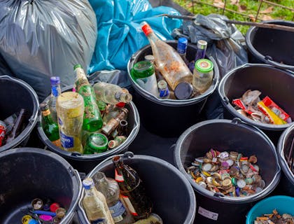 diferentes contenedores negros con diferentes tipos de basura para ser reciclada en un centro de reciclaje