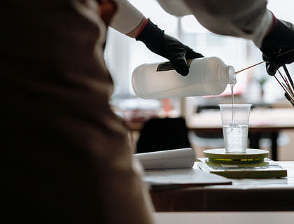 A person pouring resin into a cup.