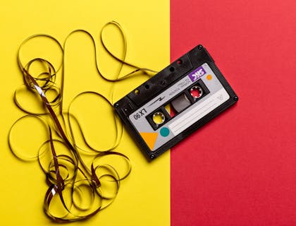 Un casete negro sobre un fondo retro de color amarillo y rojo.