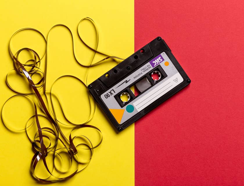 Black cassette tape on a retro yellow and red background.