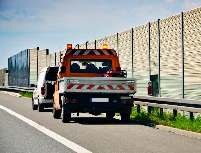 Un servizio di soccorso stradale con carroattrezzi sulla corsia d'emergenza di un'autostrada.