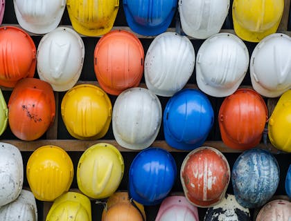 Cascos apilados en una rejilla de alambre en un negocio de seguridad industrial.