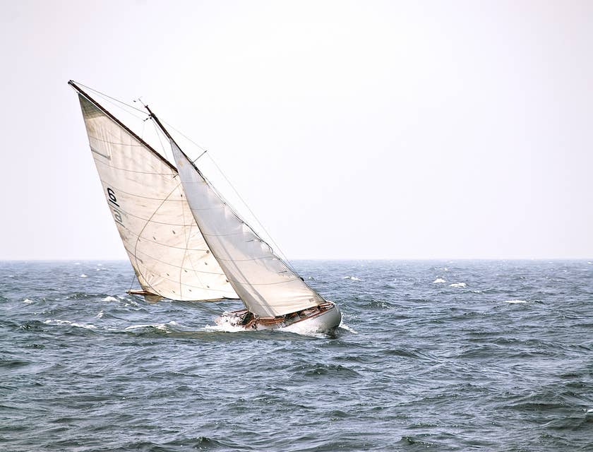 A sailboat roll tacking while sailing on choppy waters.