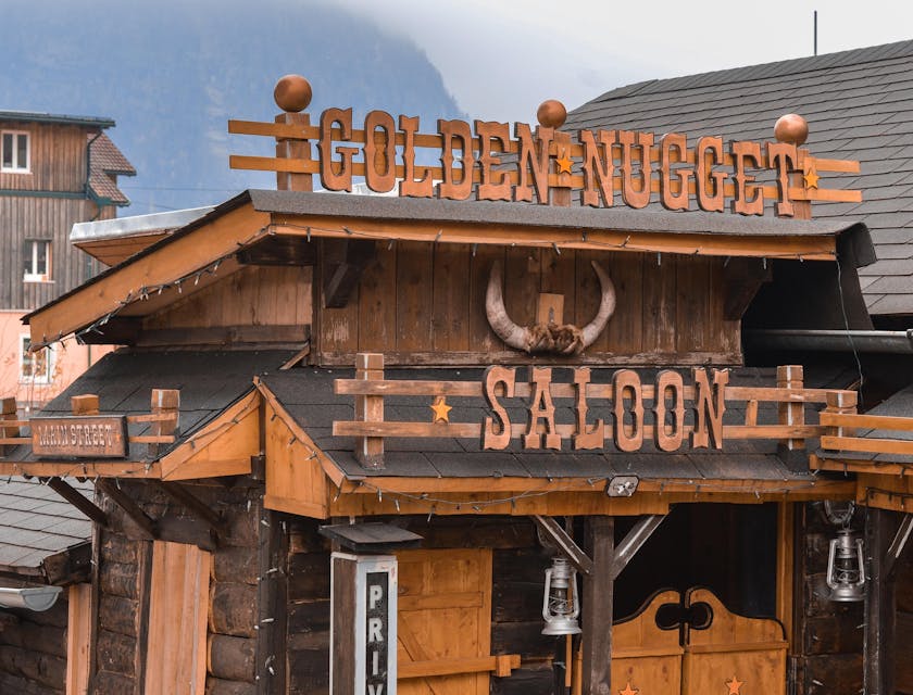 An old building facade with the words "Golden Nugget Saloon" mounted to the wall.