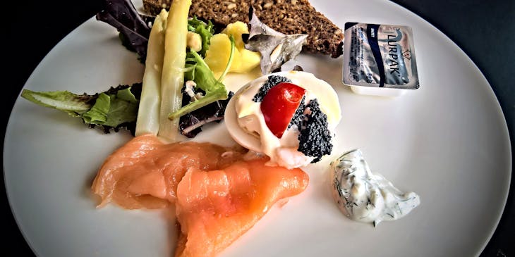 Scandinavian dish with salmon and rye bread on a white ceramic plate.