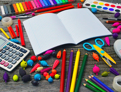 Colorful school supplies set out on a desk.