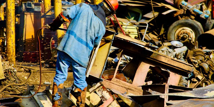 A person sorting through scrap metal.