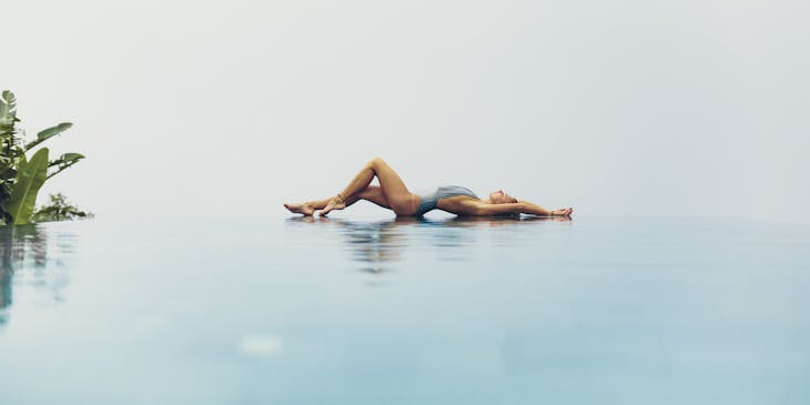 Flexible woman lying on poolside at a sensual business.