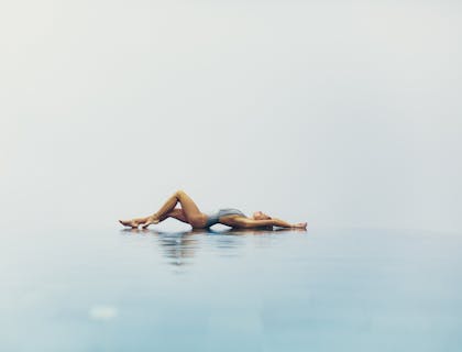 Une femme flexible allongée au bord de la piscine lors d'une activité sensuell.e