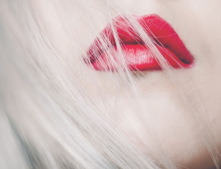 Cheveux blonds sur lèvres rouges.