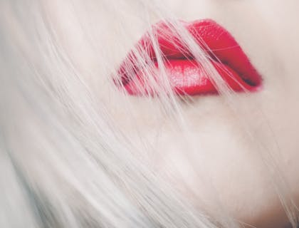 Cheveux blonds sur lèvres rouges.
