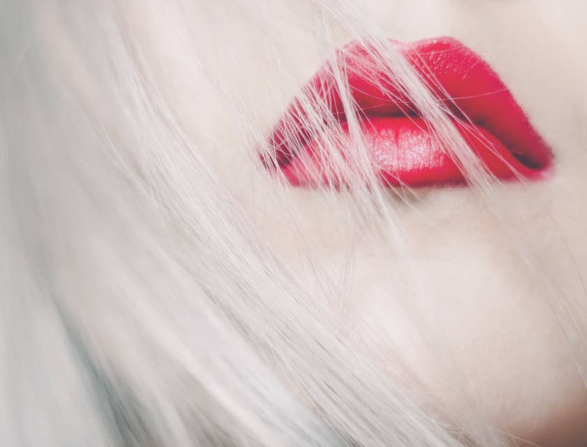 Blond hair blowing over red lips