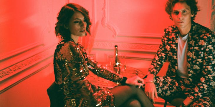 A man and woman sitting together in a sexy club.