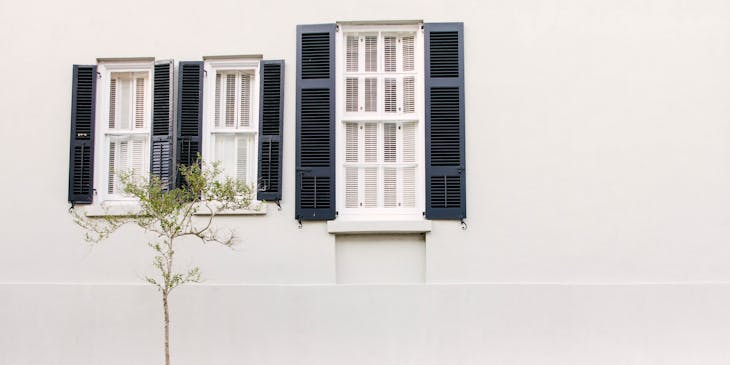 Des volets bleus sur une maison blanche.