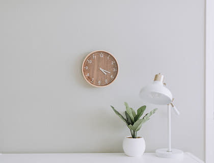 Una lámpara simple y una planta en un escritorio blanco en un negocio con nombre simple.