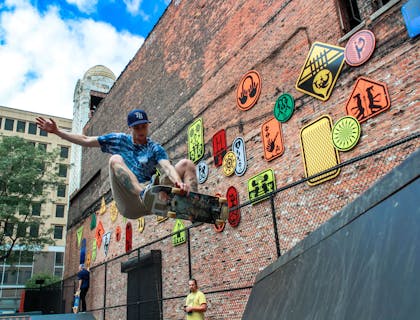 A skateboarder at a skate park doing tricks.