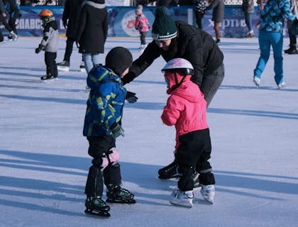 Niños patinando en una pista de patinaje de hielo.