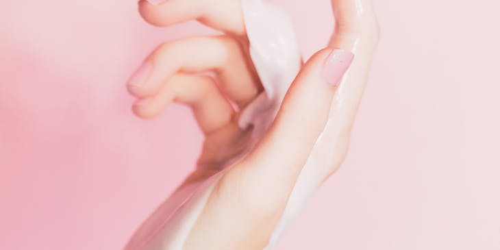 Lotion being poured on woman's skin as a skincare routine.