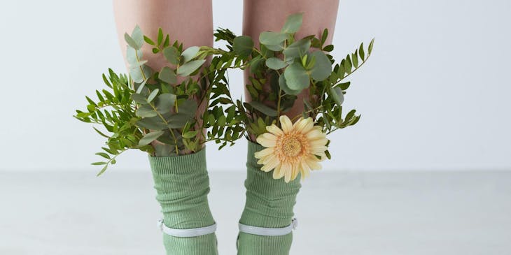 A girl wearing socks and high heels with flowers tucked in the socks.