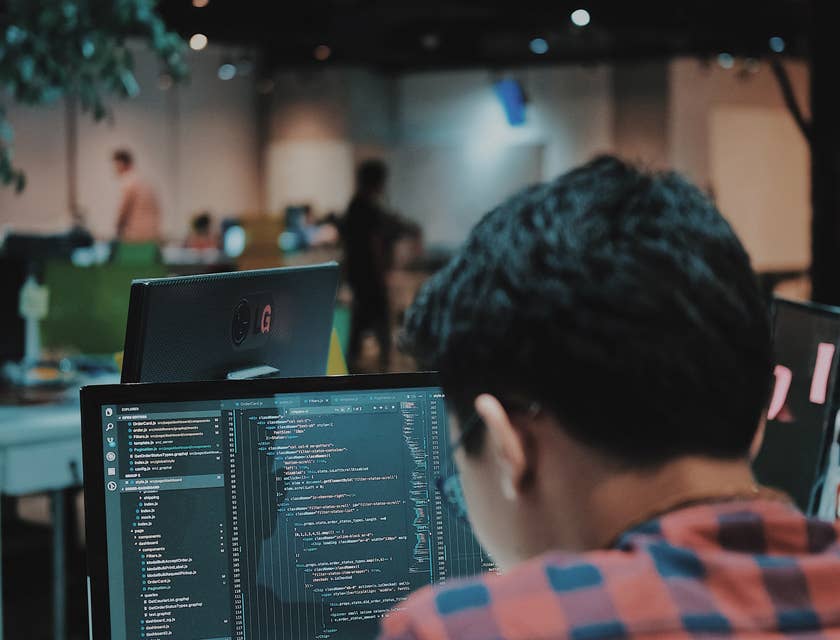 Un software developer o programmatore che lavora su un software al computer dentro un ufficio di un'azienda di sviluppo software.