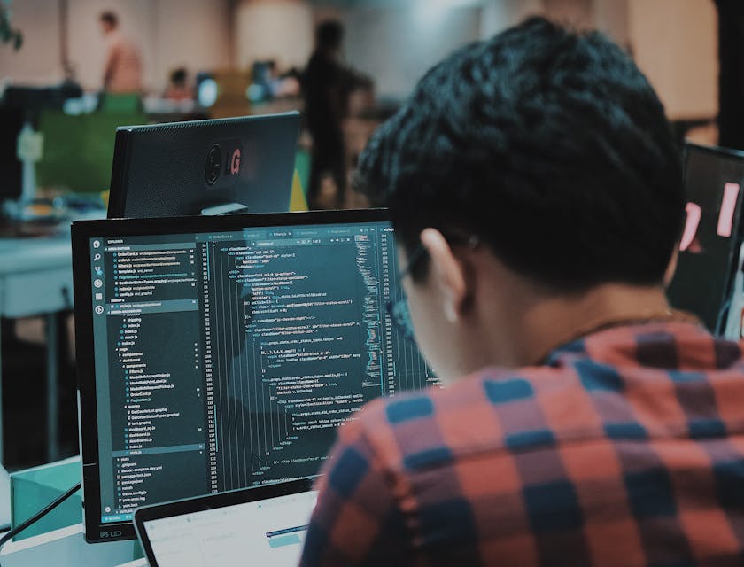 Software developer looking at computer monitors.