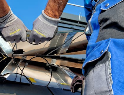 Un hombre instalando un panel solar en una empresa de paneles solares.
