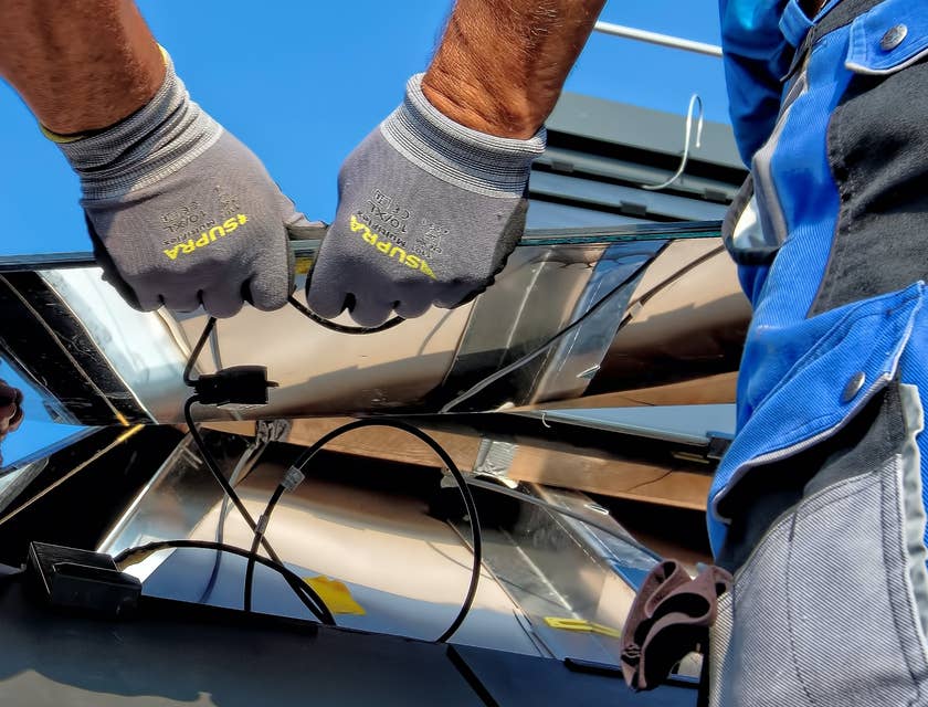 Angestellte einer Solarfirma montieren eine Solaranlage auf einem Dach.