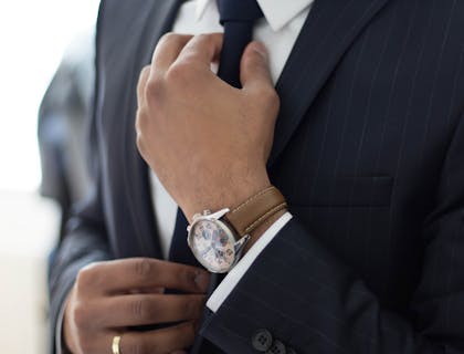 A sophisticated man fastening his tie.