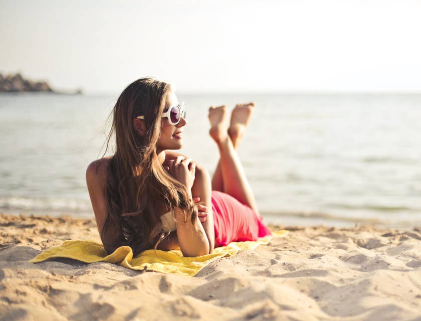 Une femme avec un autobronzant à la plage.