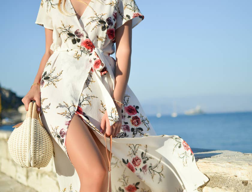 Una donna che indossa uno stiloso vestito a fiori in spiaggia.