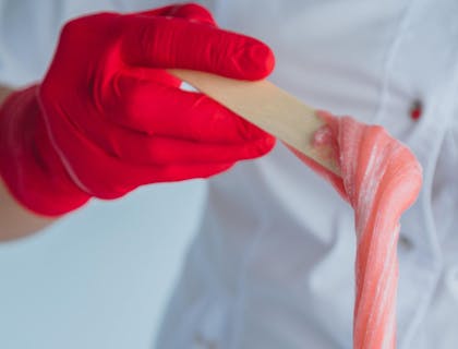 A therapist preparing the product at a sugaring business.