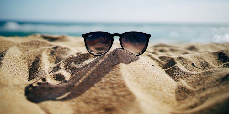 Pair of sunglasses on a beach.
