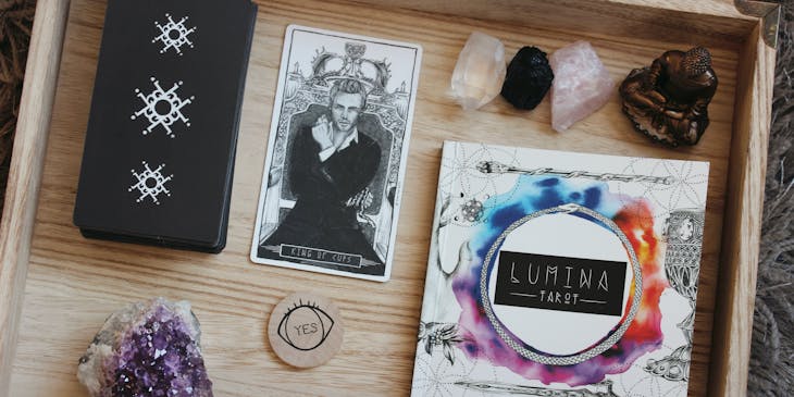 Table with tarot cards and crystals on it.