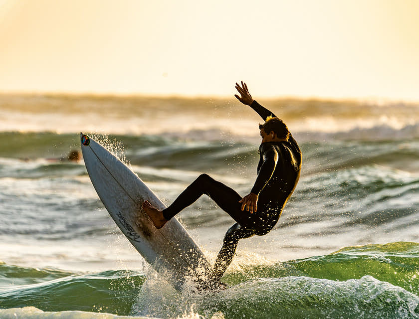 Homem pegando uma onda em uma prancha de surf.