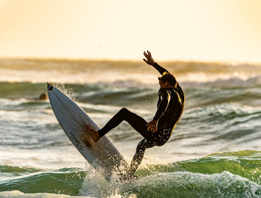 Un uomo che fa surf in spiaggia.