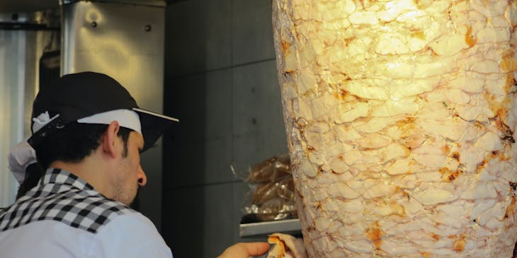 Man making shawarma in a Syrian restaurant.