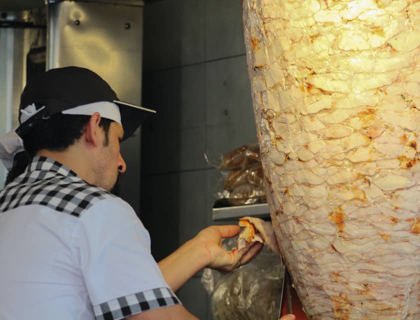 Homem fazendo shawarma em um restaurante sírio.