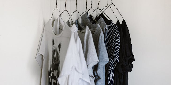 Several T-shirts hanging on a rack at a T-shirt business.