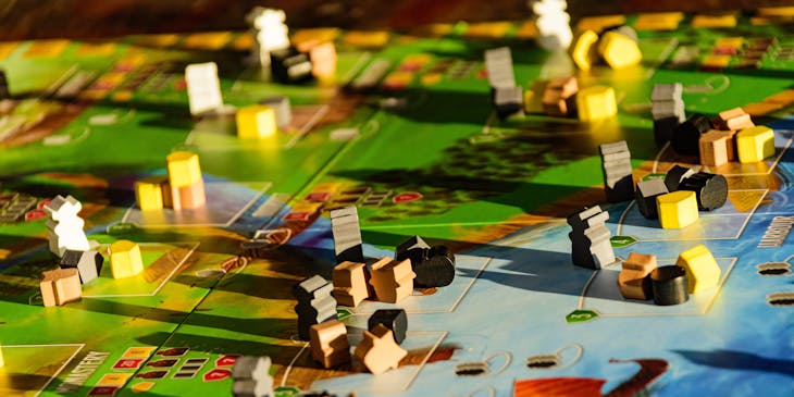 Board game with small markers spread out over a landscape.