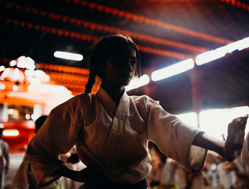 Une fille en costume blanc lors d'un entraînement de taekwondo.