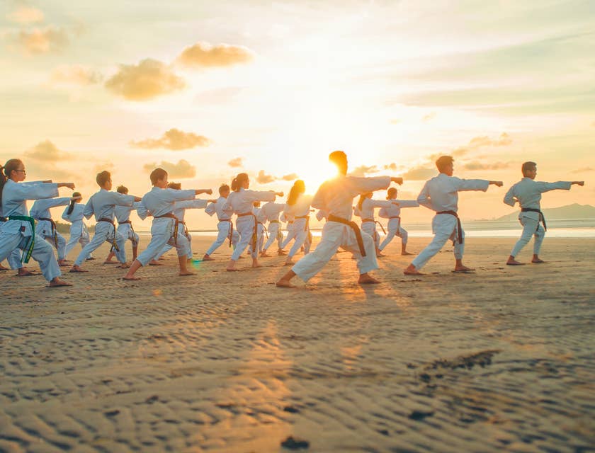 People practicing Tai Chi on a beach.