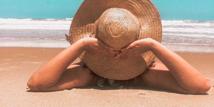 A woman tanning at the beach.