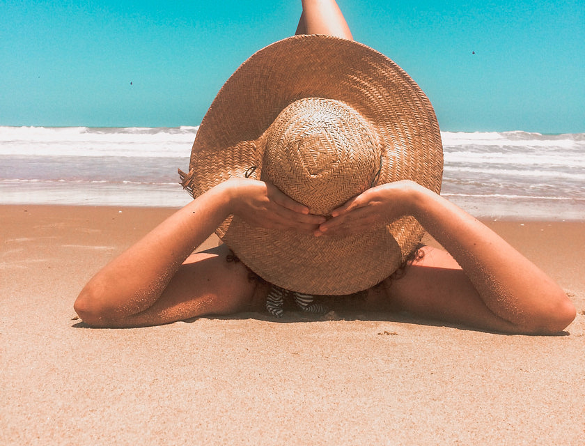 mujer bronceándose en la playa