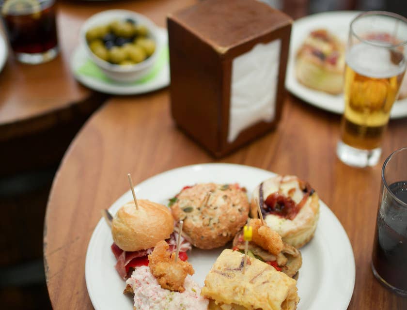 Two plates of tapas served with drinks.