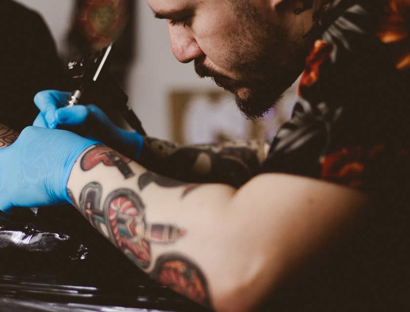 Tatuador trabalhando em um estúdio de tatuagem